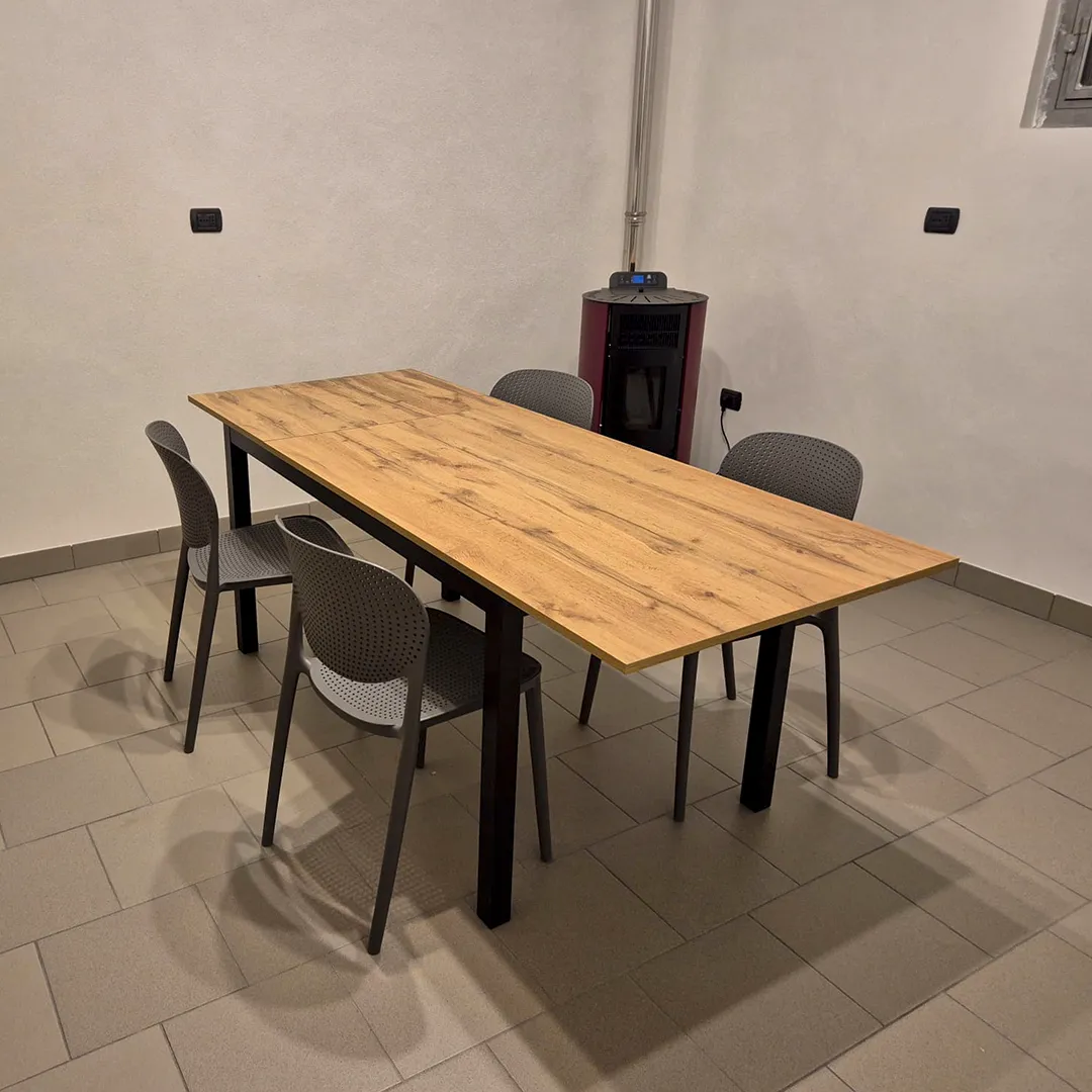 Tavolo moderno da cucina in legno rovere naturale con sedie grigie e cucina coordinata. 